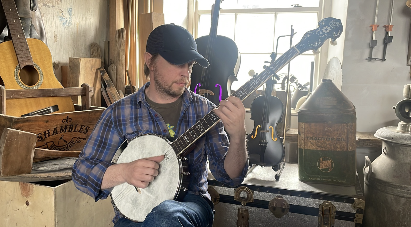 Ciaran playing banjo in an instrument shop