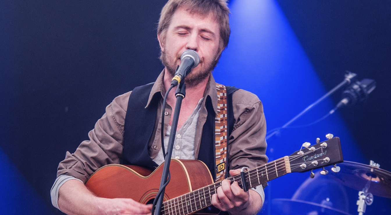 Ciaran singing and playing guitar on stage