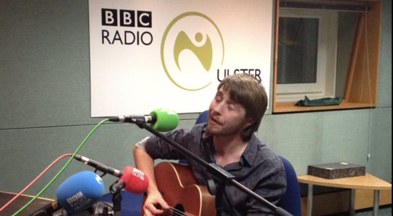 Ciaran playing guitar in the BBC Radio Ulster studio